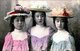 Japan: Three young women dressed in Western fashion. Hand-tinted photograph c. 1895, probably by T. Enami